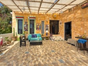 Bright outdoor patio with colorful artwork and cozy seating, ideal for relaxing in a charming Mexica. Isla Mujeres Mexico Property