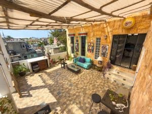 Balcony with colorful doors, outdoor seating, and potted plants in a vibrant residential space. Isla Mujeres Mexico Property