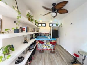 Bright modern kitchen with colorful tiled island, white walls, and open shelving for a stylish home. Isla Mujeres Mexico Property