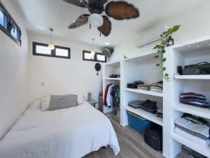 Modern bedroom with built-in closet and ceiling fan in a bright, minimalist design. Isla Mujeres Mexico Property