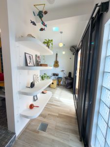 Bright indoor space with white shelves, musical instruments, and decorative items in a modern home. Isla Mujeres Mexico Property